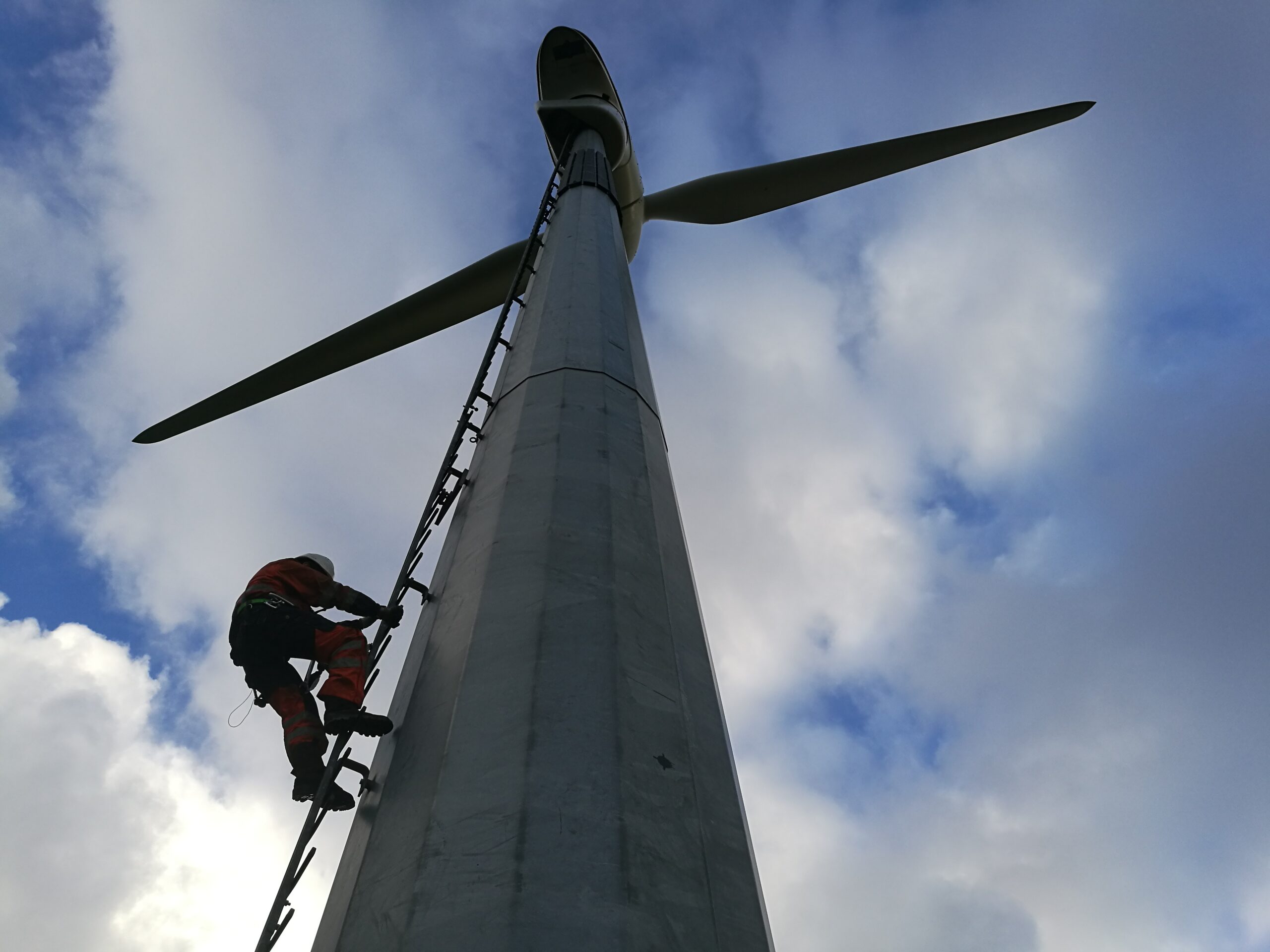 cof Engineer climbing wind turbine tower to assess tonal noise and vibration