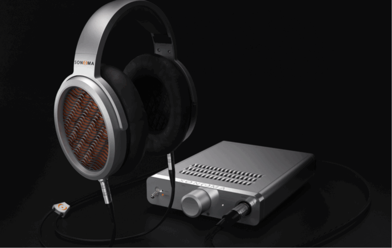 Close-up of over-ear Sonoma headphones connected to a sleek silver desktop headphone amplifier on a black background.
