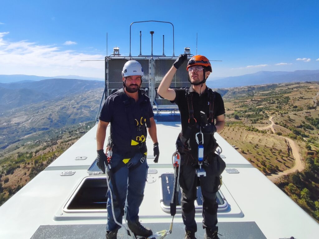 Engineering professionals working at height on an industrial installation, equipped with safety gear and field instrumentation, representing practical leadership, delivery responsibility, and teamwork in real-world engineering settings.